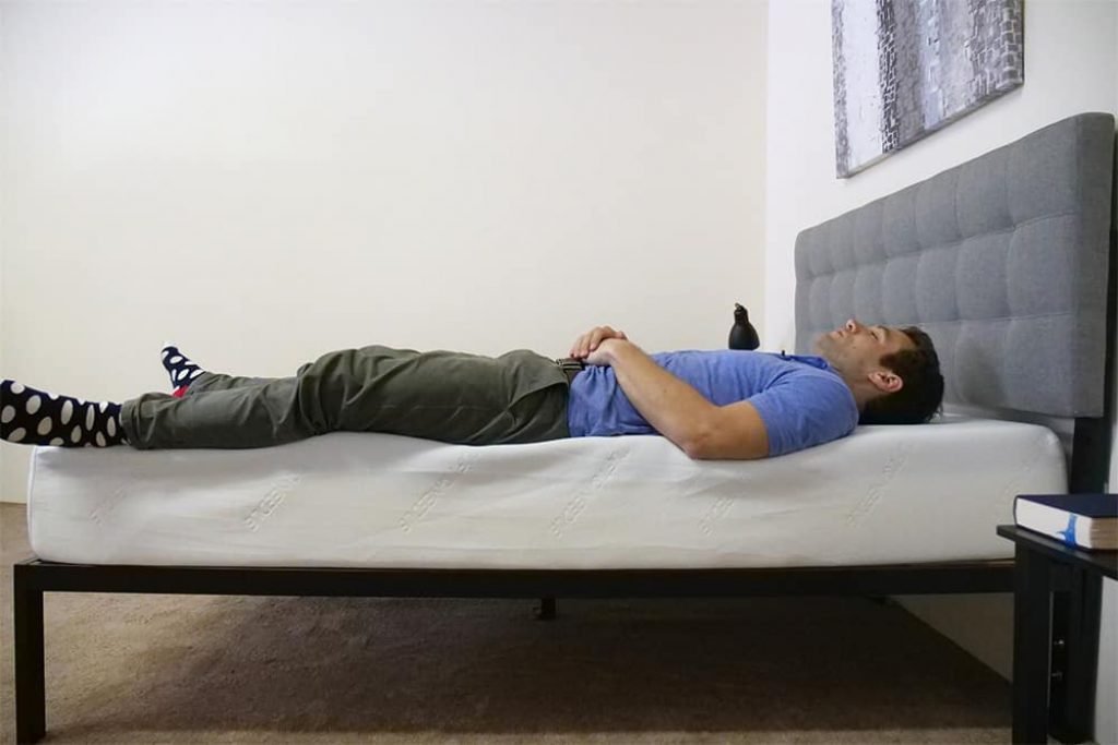 A man is sleeping on a mattress